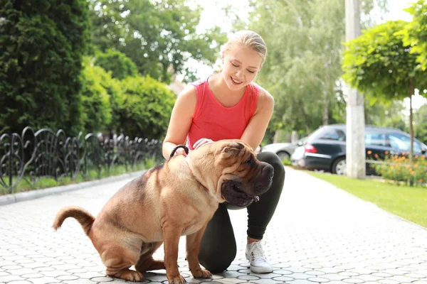 Sporty woman with cute dog walking outdoors — Stock Photo, Image