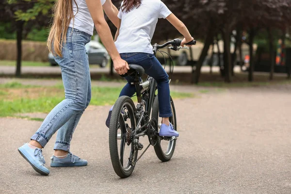 Η μητέρα διδάσκει την κόρη της να πάει ποδήλατο σε εξωτερικούς χώρους — Φωτογραφία Αρχείου