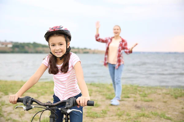 Matka hrdá na svou dceru, která se naučila jezdit na kole venku — Stock fotografie