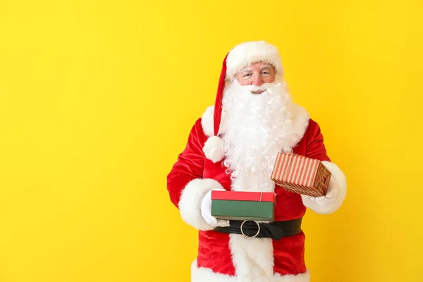 Санта-Клаус с подарками на цветном фоне — стоковое фото