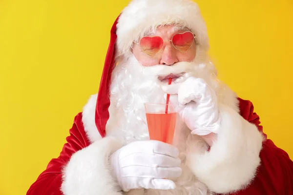 Święty Mikołaj picie koktajl na kolorowym tle — Zdjęcie stockowe