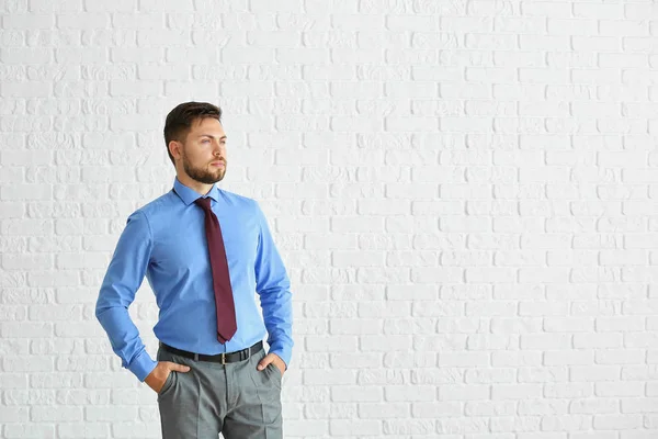 Retrato de hombre de negocios elegante contra la pared de ladrillo blanco — Foto de Stock