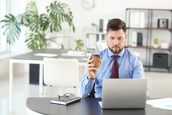 Portrait of businessman drinking coffee in office — Stock Photo, Image