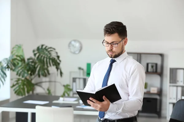 Porträt eines Geschäftsmannes mit Notizbuch im Büro — Stockfoto