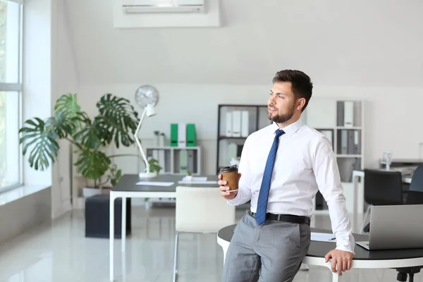 Portrait of businessman with cup of coffee in office — Stock Photo, Image