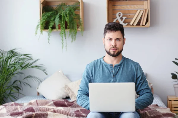 Портрет красивого чоловіка з ноутбуком вдома — стокове фото
