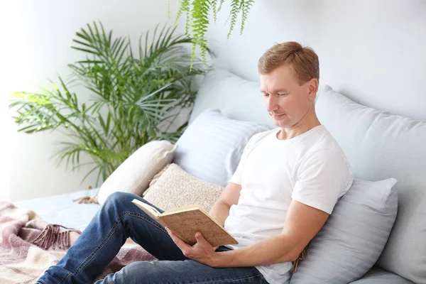 Porträt eines gutaussehenden Mannes, der zu Hause Buch liest — Stockfoto