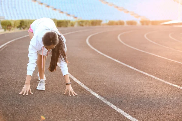 Sporty Asian woman in crouch start position at the stadium — Stock Photo, Image
