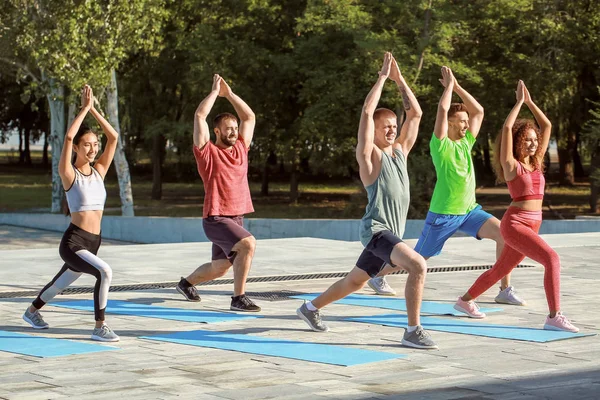 Grupo de jóvenes deportistas entrenando juntos al aire libre — Foto de Stock