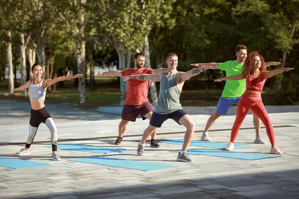 Grupo de jóvenes deportistas entrenando juntos al aire libre — Foto de Stock
