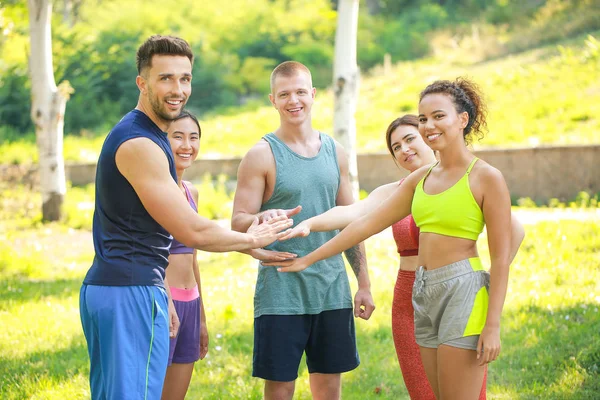 Grupa młodych ludzi sportowy, łącząc ręce na zewnątrz — Zdjęcie stockowe