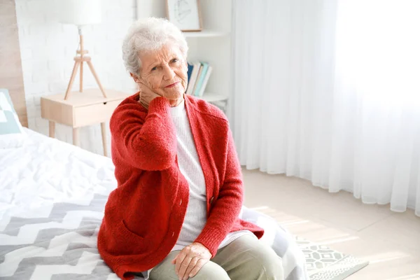 Senior nő szenved fájdalmat a nyak otthon — Stock Fotó