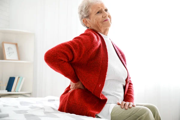 Mujer mayor que sufre de dolor en la espalda en casa — Foto de Stock