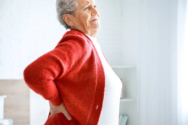 Mujer mayor que sufre de dolor en la espalda en casa — Foto de Stock