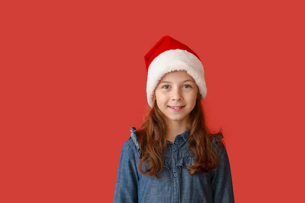 Linda niña en el sombrero de Santa Claus en el fondo de color —  Fotos de Stock