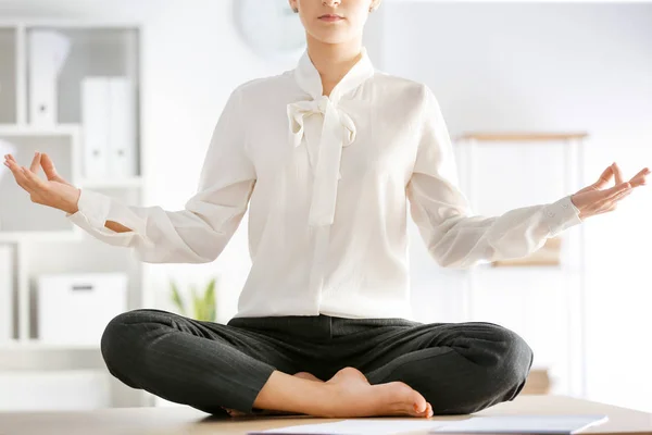 Молодая предпринимательница медитирует в офисе — стоковое фото