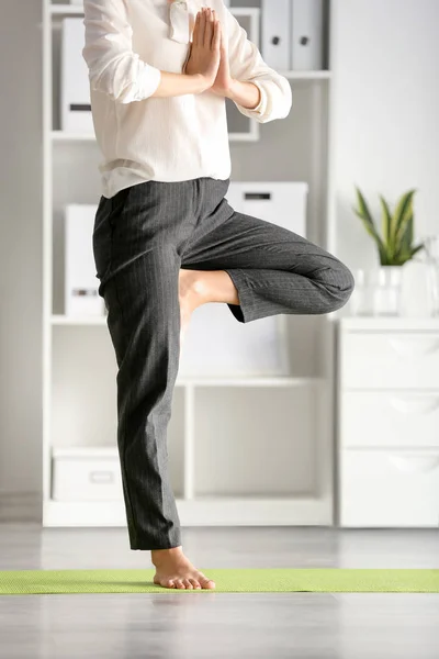 Young businesswoman practicing yoga in office — Stock Photo, Image