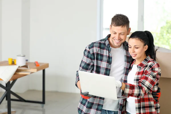 Pareja feliz con diseño de planificación portátil de su nueva casa — Foto de Stock