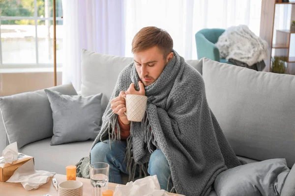 自宅で熱いお茶を飲む病気の男 — ストック写真