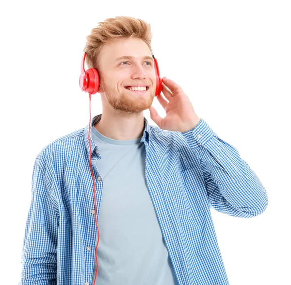 Guapo joven escuchando música sobre fondo blanco — Foto de Stock