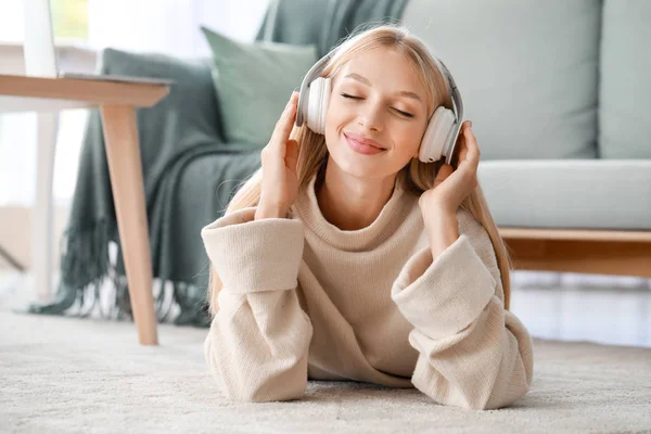 Gyönyörű fiatal nő zenét hallgat otthon. — Stock Fotó