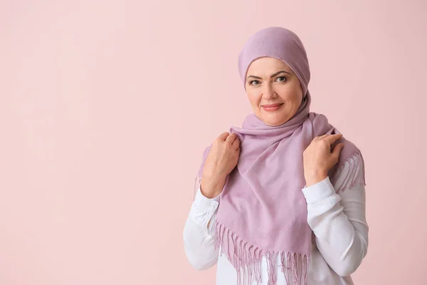 Mooie rijpe moslim vrouw op kleur achtergrond — Stockfoto