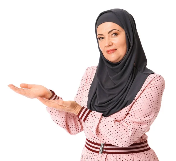 흰색 배경에 뭔가를 보여주는 아름다운 성숙한 무슬림 여자 — 스톡 사진