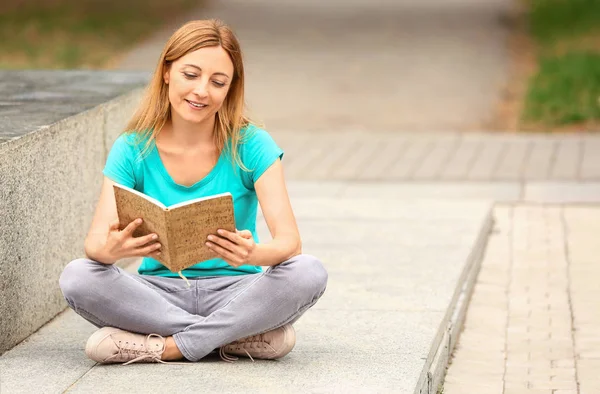 Woman reading book outdoors on summer day — Stock Photo, Image