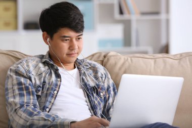 Dizüstü bilgisayar ile Asyalı öğrenci evde sınava hazırlanıyor