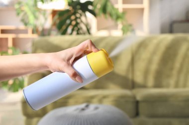 Kadın evde oda spreyi püskürtme