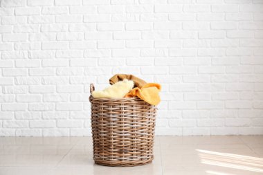 Beyaz tuğla duvara yakın katta çamaşır sepeti