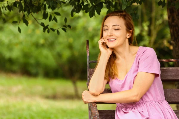 Woman relaxing on bench in park — Stock Photo, Image