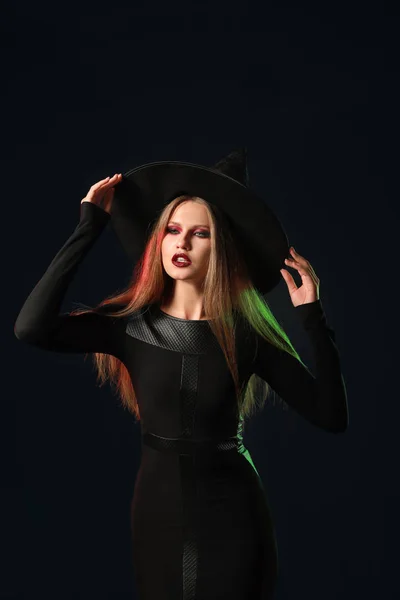 Vacker kvinna klädd som häxa för Halloween på mörk bakgrund — Stockfoto