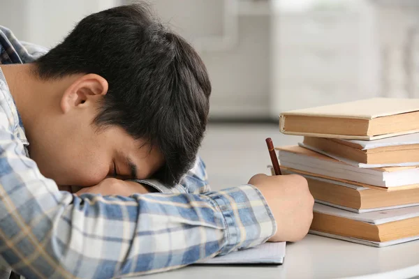 Fatigué asiatique étudiant dormir à table — Photo