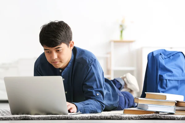 Asian student with laptop preparing for exam at home