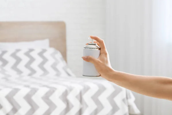 Vrouw spuiten luchtverfrisser in slaapkamer — Stockfoto