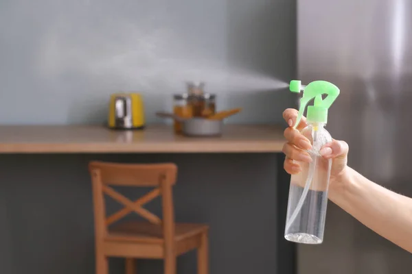 妇女喷洒空气清新剂在厨房 — 图库照片