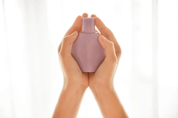 Female hands with bottle of perfume on light background — Stock Photo, Image