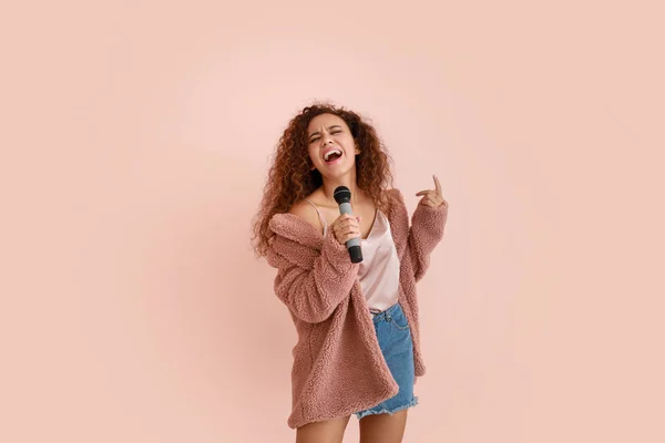 Belle chanteuse afro-américaine avec microphone sur fond de couleur — Photo