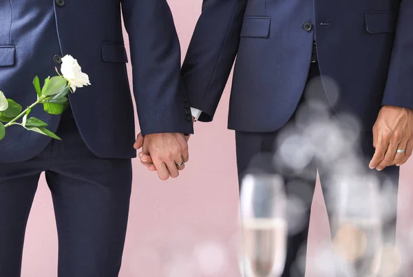 Glückliches homosexuelles Paar am Hochzeitstag vor farbigem Hintergrund — Stockfoto
