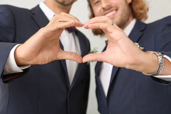 Šťastný pár gayů, který si dělá s rukama svatební den s lehkým pozadím — Stock fotografie