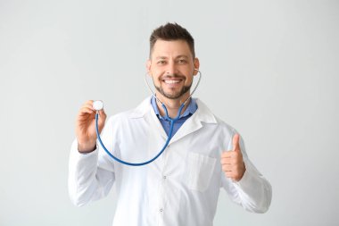 Işık arka planda stetoskop ile erkek doktor