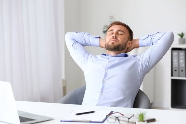 Yakışıklı genç adam işyerinde rahatlatıcı