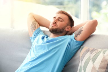 Yakışıklı genç adam evde dinleniyor.