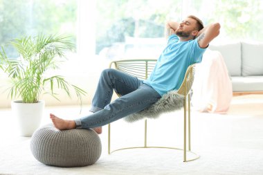 Yakışıklı genç adam evde dinleniyor.