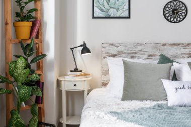 Odanın şık iç lamba ve bitkiler ile büyük rahat yatak ve masa