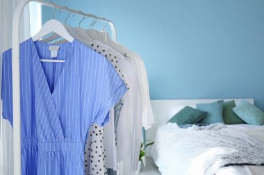 Yatak odasında asılı giysiler ile Raf