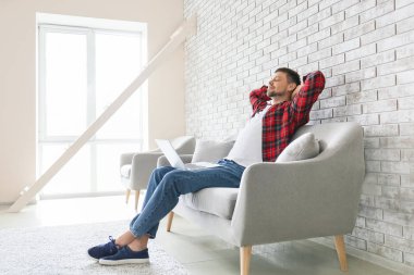 Evde rahatlatıcı dizüstü bilgisayar ile Adam