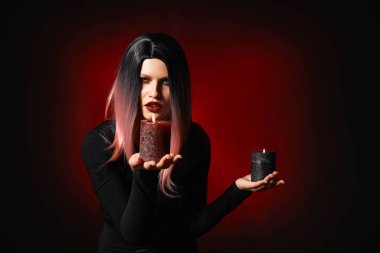 Karanlık arka planda Cadılar Bayramı için giyinmiş mumlar ile güzel kadın