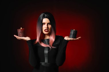Karanlık arka planda Cadılar Bayramı için giyinmiş mumlar ile güzel kadın